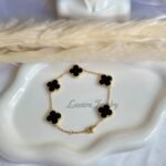 Fashion bracelet with black clover and gold plated chain.